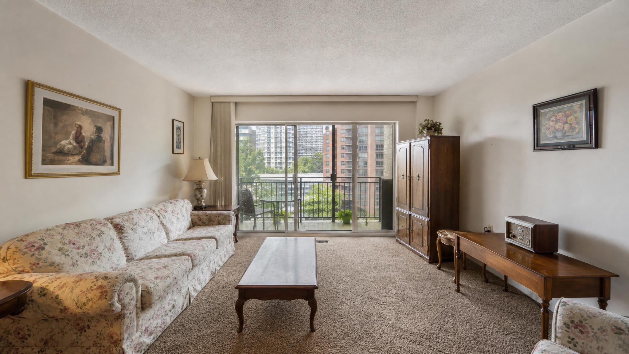 Before image of a small living room in a condo, emphasizing outdated decor.