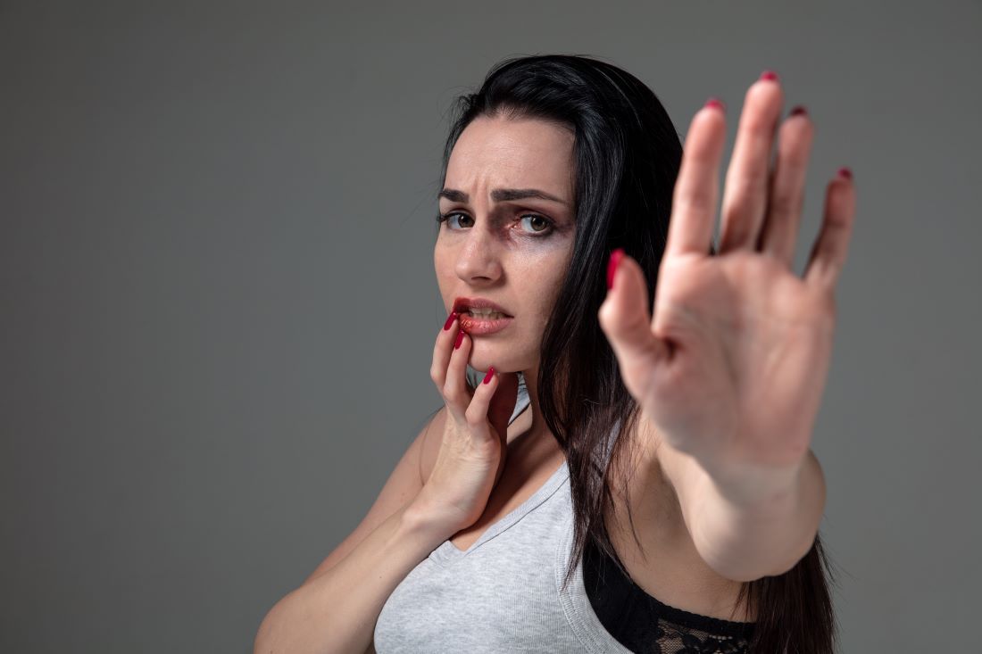 mujer morena camiseta tirantes heridas cara mano levantada