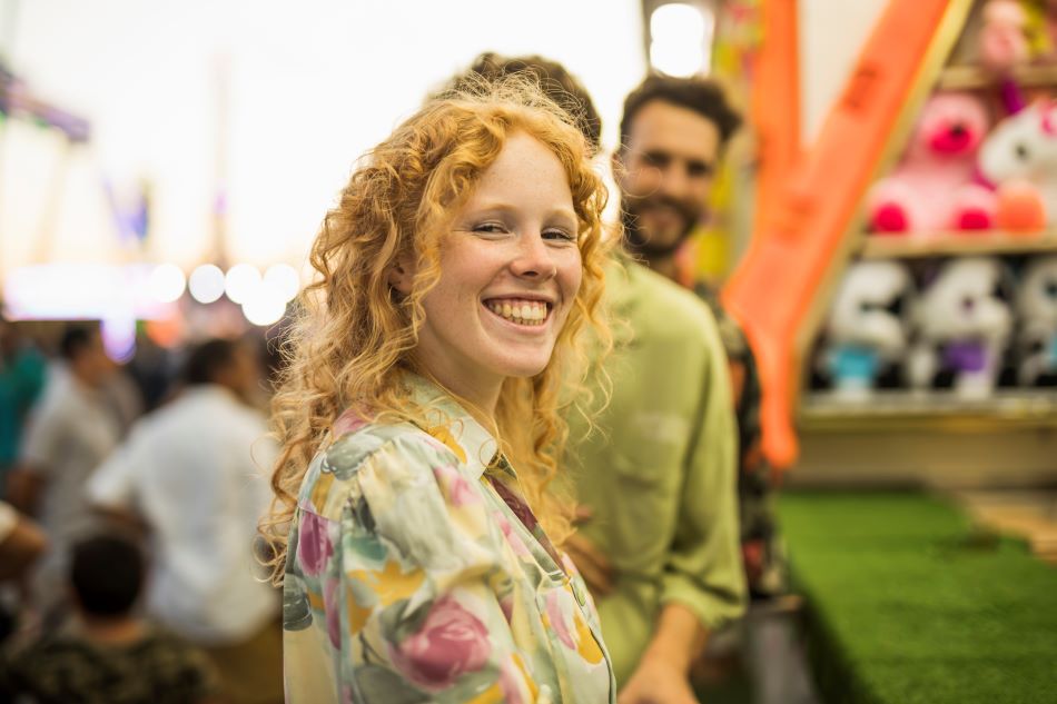 mujer pelo rizado felicidad parque atracciones 