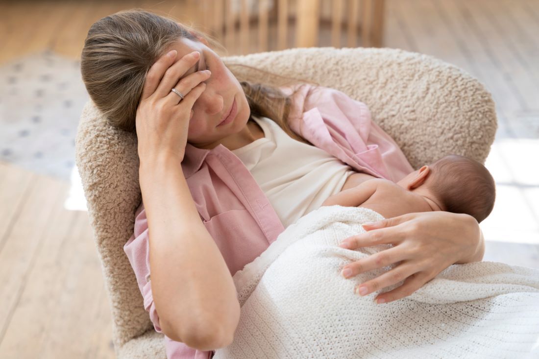 mujer sentada butaca amamantando bebe depresion posparto