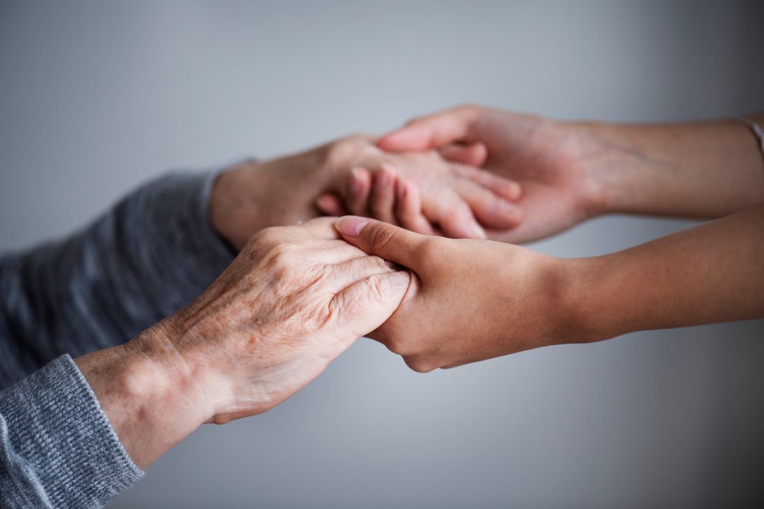 manos persona mayor y joven entrelazadas parkinson