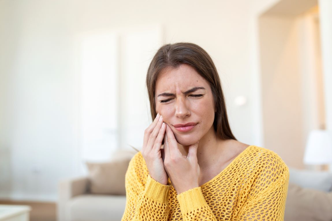 mujer joven jersey amarillo dolor dientes