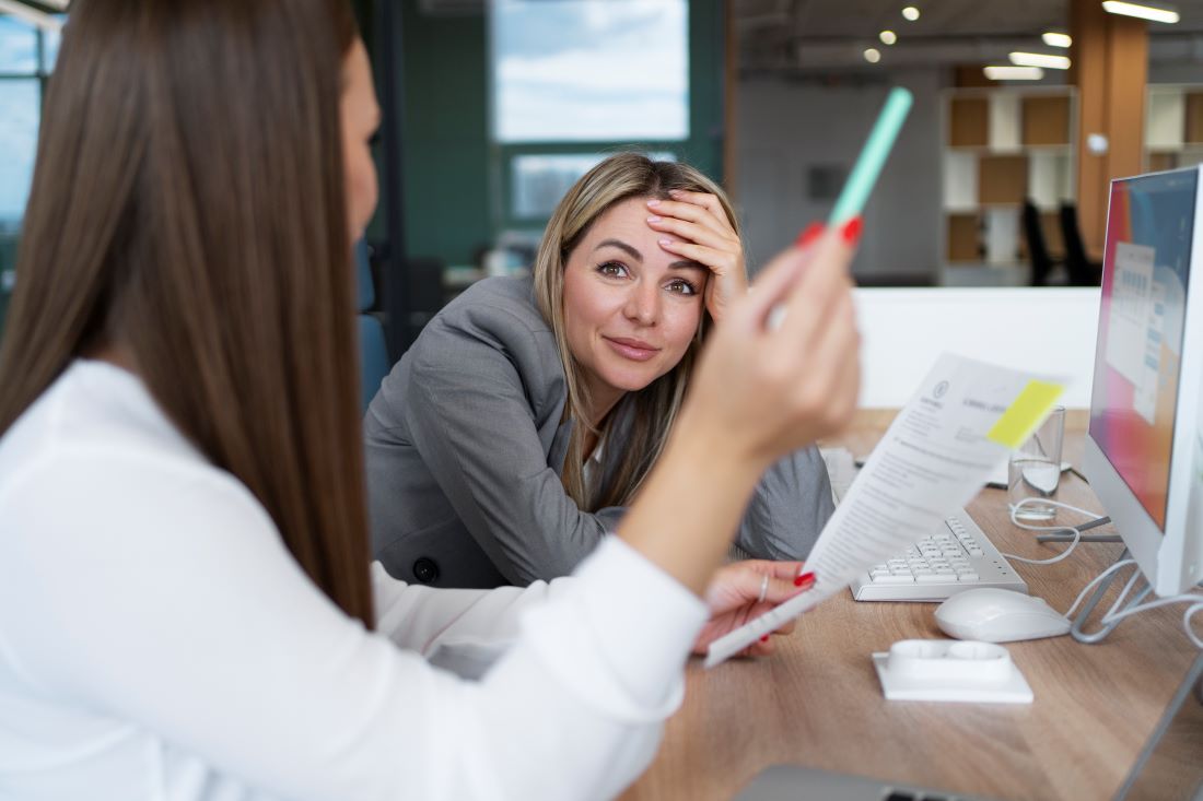 mujer mano cabeza apoyada mesa trabajo hablando