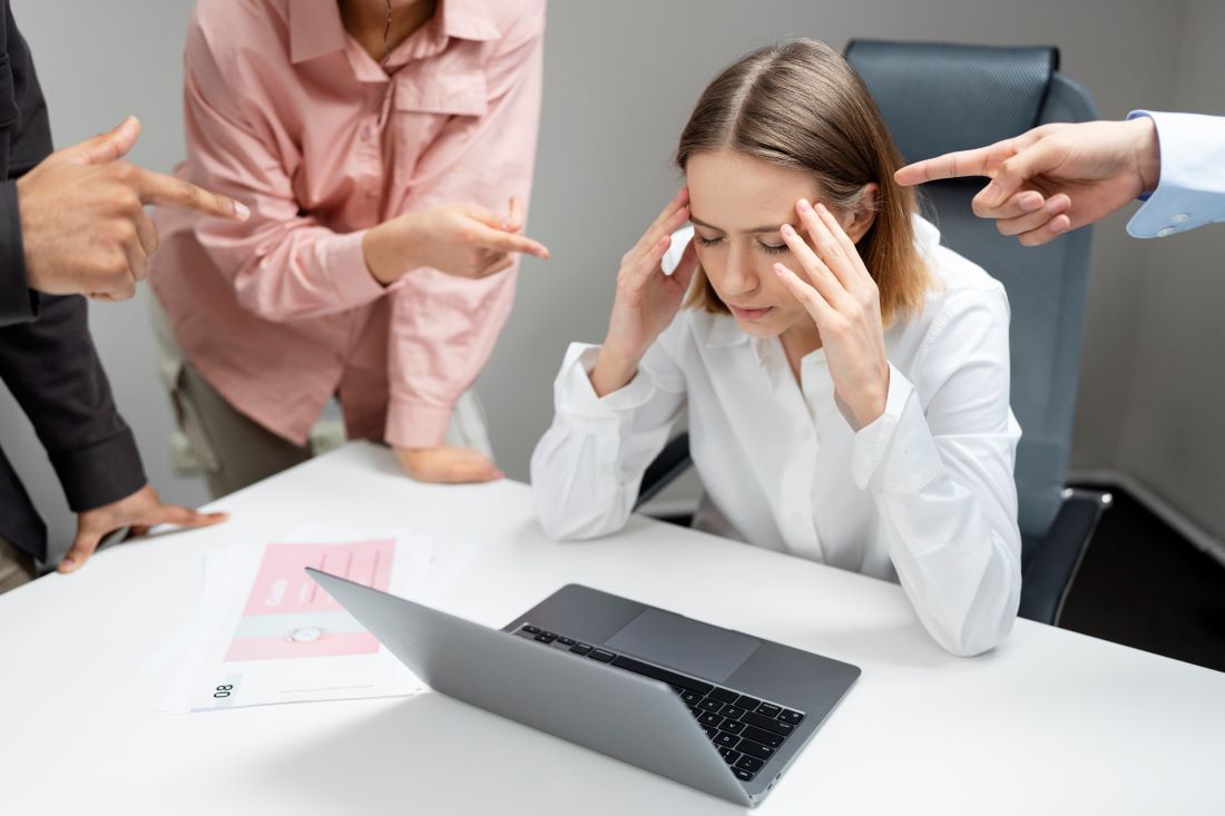 mujer señalada trabajo manos cabeza portátil estrés laboral