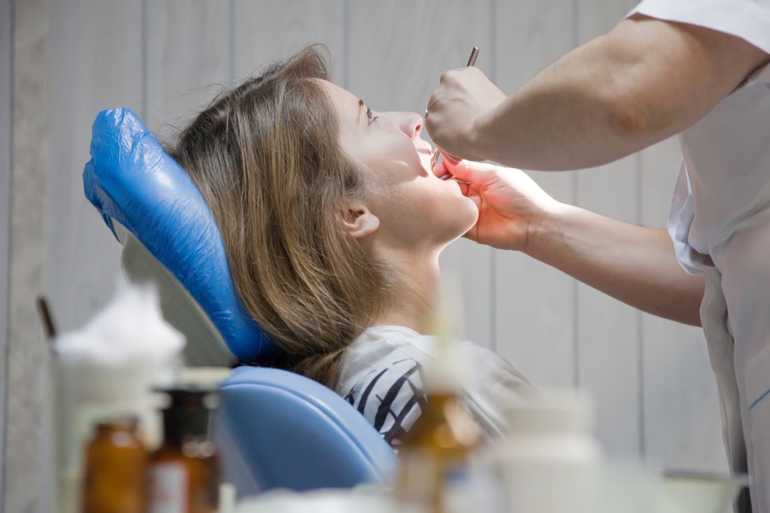 mujer pelo corto tumbada camilla consulta dentista ortodoncia