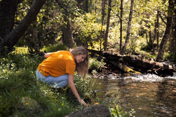 mujer camiseta naranja campo lago
