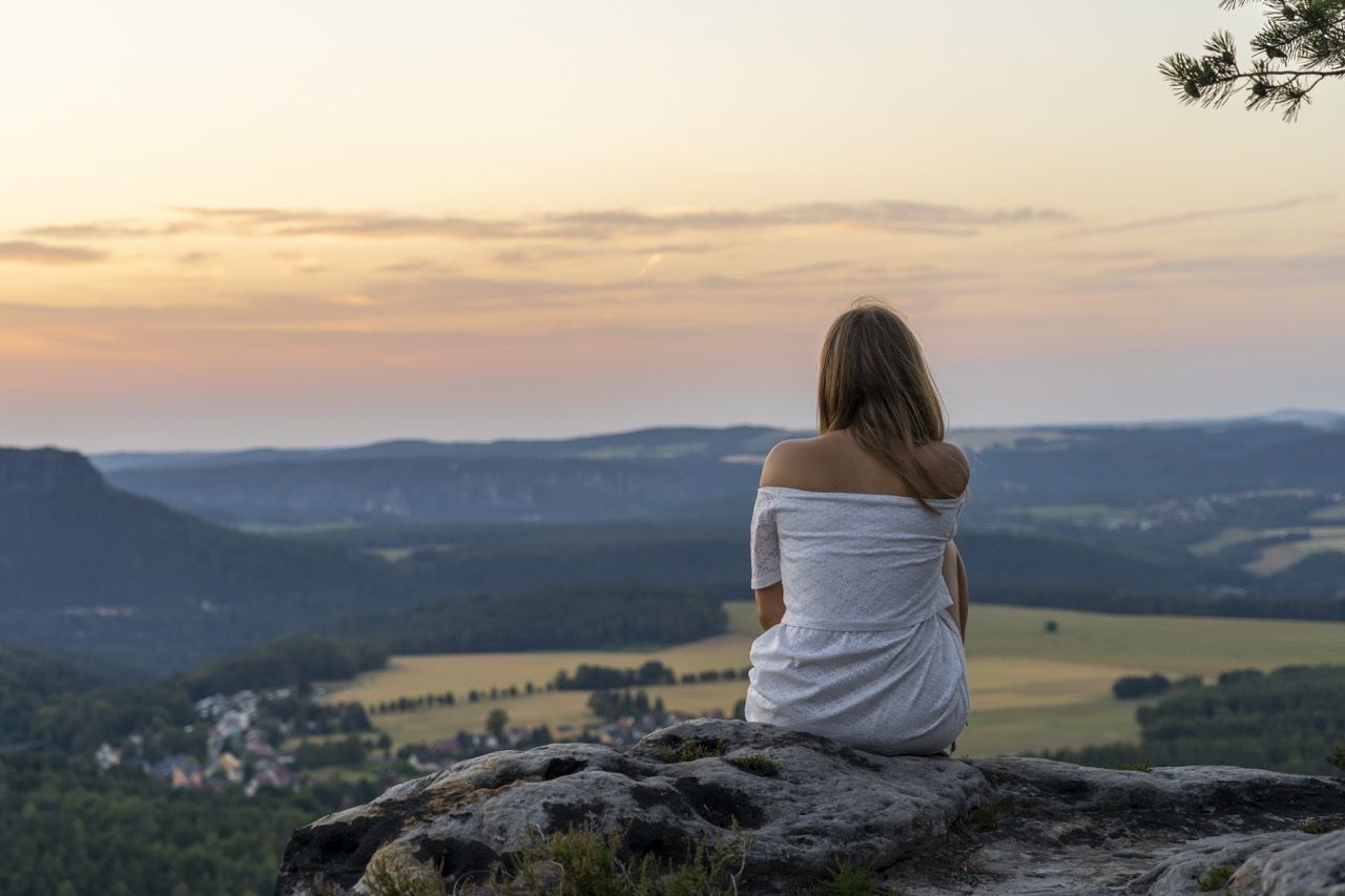mujer de espaldas sentada admirando paisaje montañas liderazgo personal