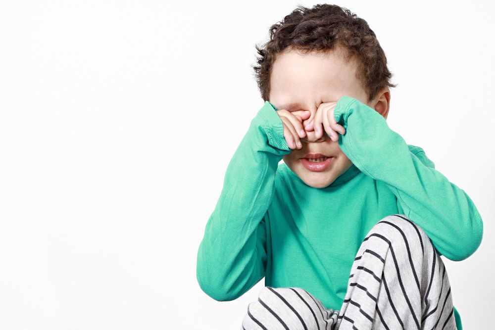 criança coçando o olho (possível conjuntivite)