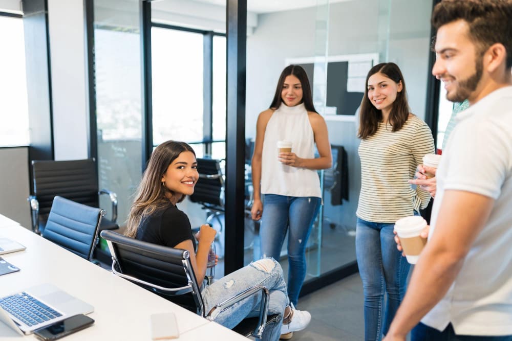 oficina compañeros hablando socializando café sonriendo tres chicas un chico