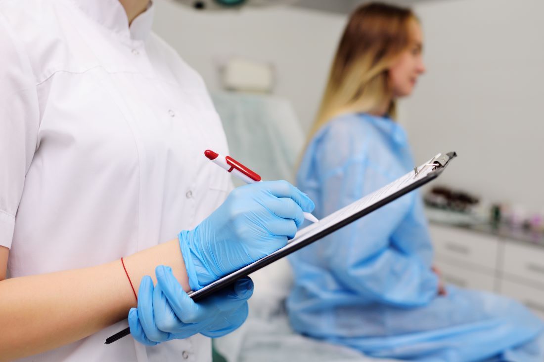 ginecóloga escribe boligrafo carpeta consulta paciente 