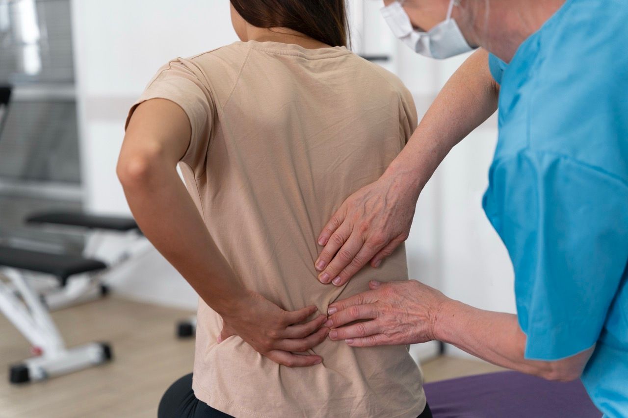 medico tocando espalda mujer sentada hernia discal