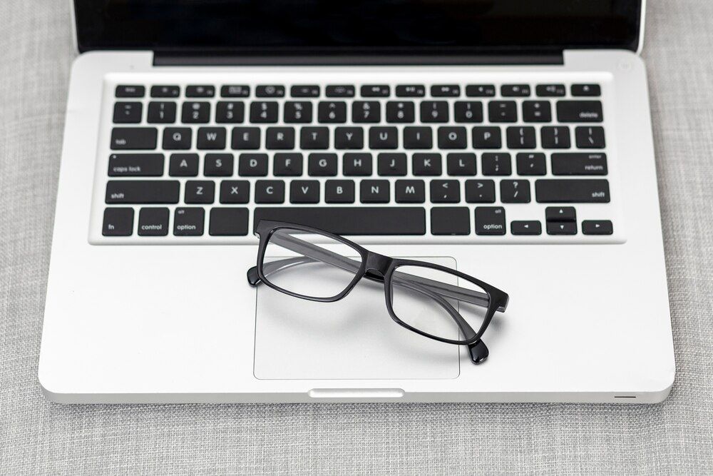 ângulo alto de laptop com par de óculos