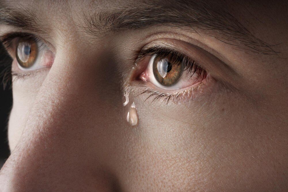 close-up dos olhos de um homem jovem chorando com lágrimas