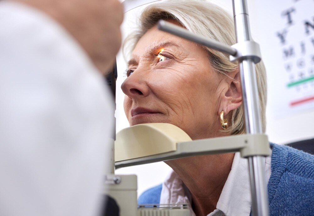 exame de vista, visão ou teste a laser para uma mulher com uma máquina em consulta de optometria para problema de retina, paciente idosa ou cliente madura com plano de saúde verificando a visão na ótica.
