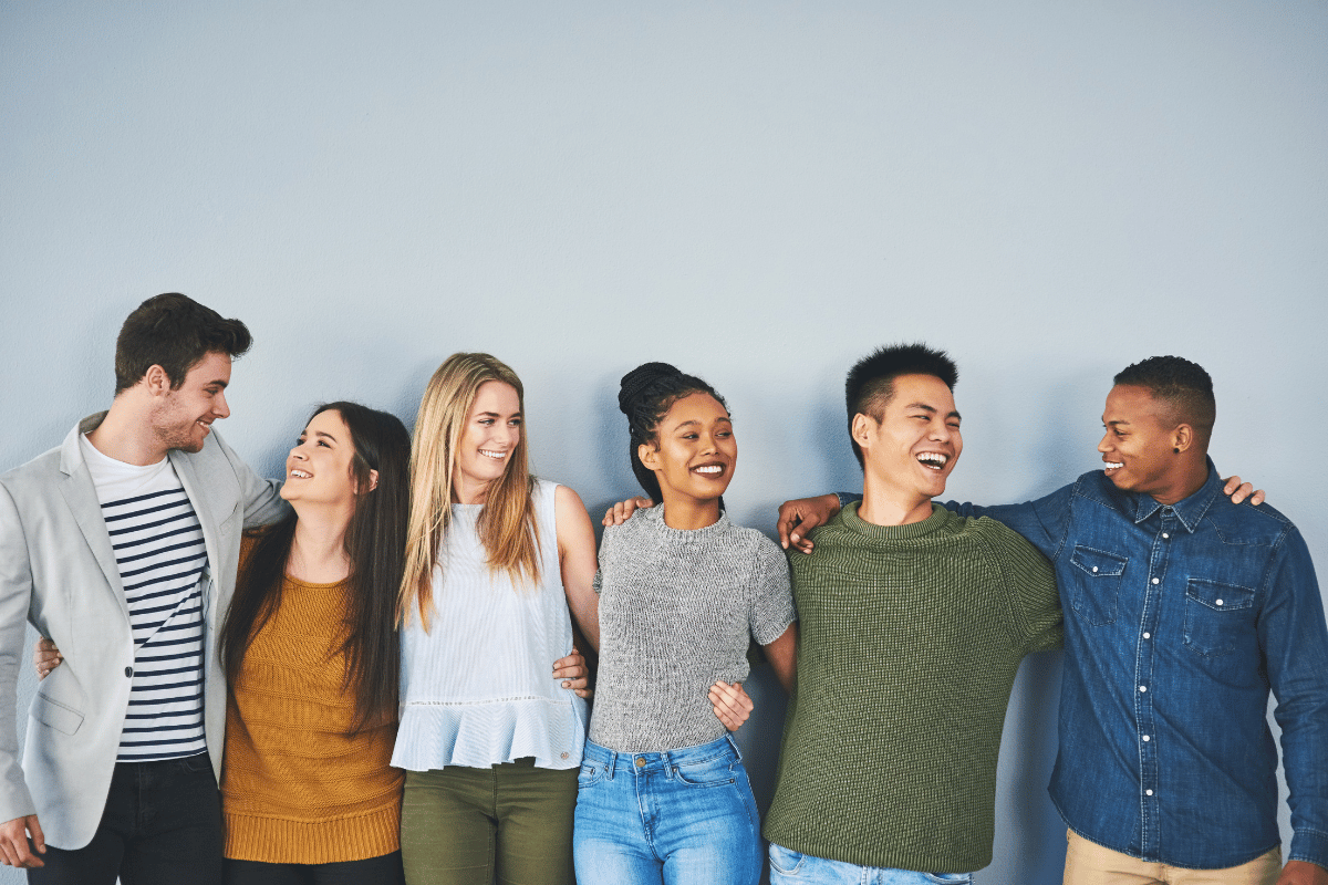 Šest lidí, kteří se objímají a smějí se