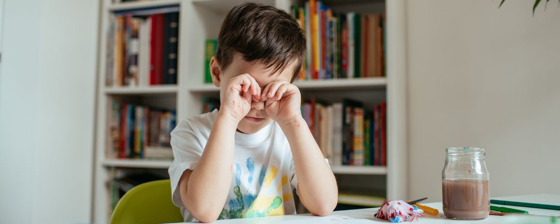 bambino seduto si stropiccia gli occhi