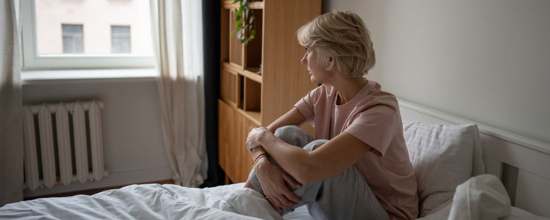 Una ragazza triste che guarda fuori dalla finestra