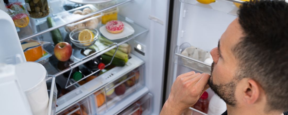 uomo guarda il frigo aperto