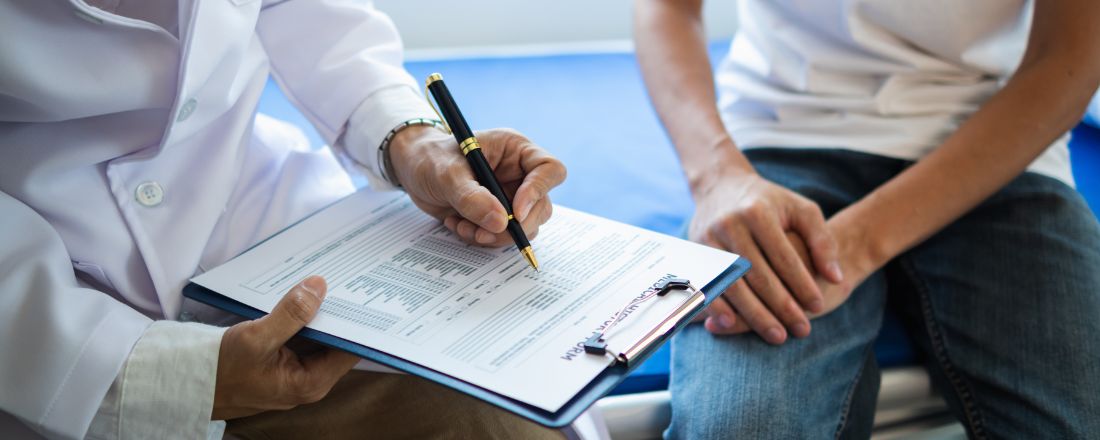 Un giovane uomo cerca un consulto con uno specialista per identificare la causa del suo dolore. Sono entrambi seduti sul lettino 