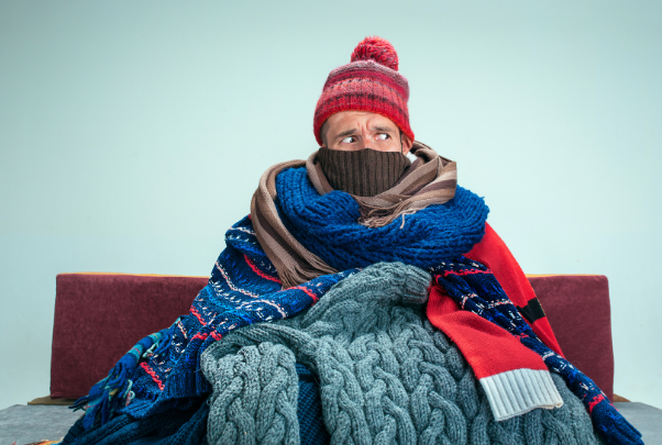 Un uomo è ricoperto di vestiti e si guarda attorno spaventato e con circospezione