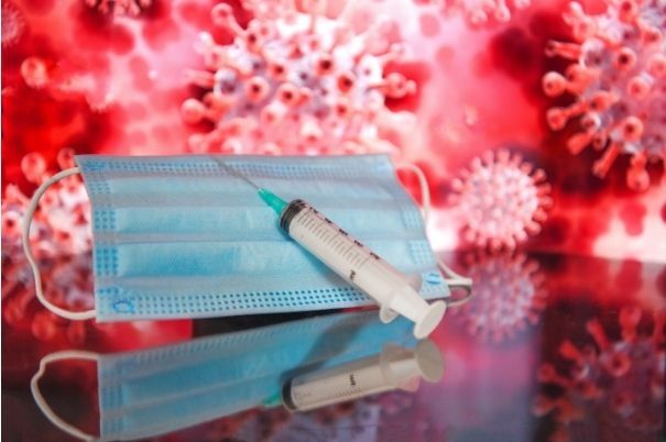 Vaccino Anticovid su Mascherina con Coronavirus sullo Sfondo