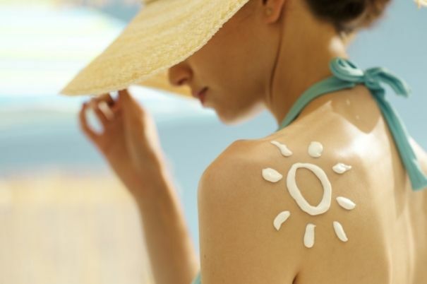 Crema Solare sulla Spalla di una Donna al Mare