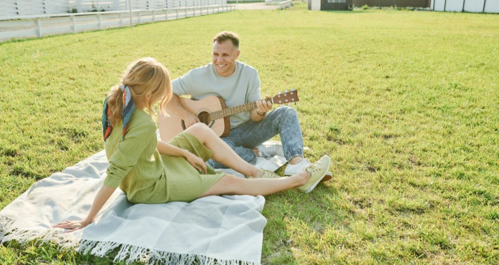uomo alla chitarra e donna nel prato