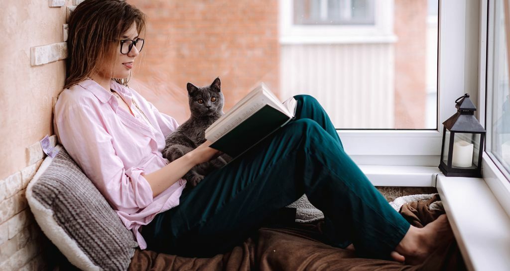 ragazza legge con il suo gatto