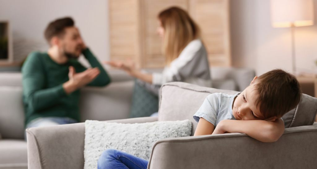 bambino triste mentre i genitori discutono