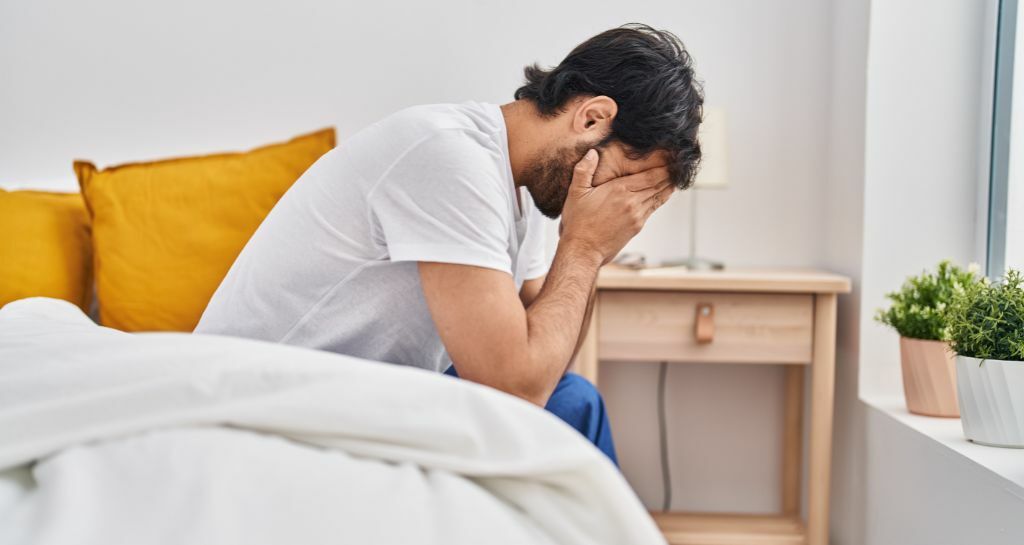 ragazzo pensa seduto sul letto