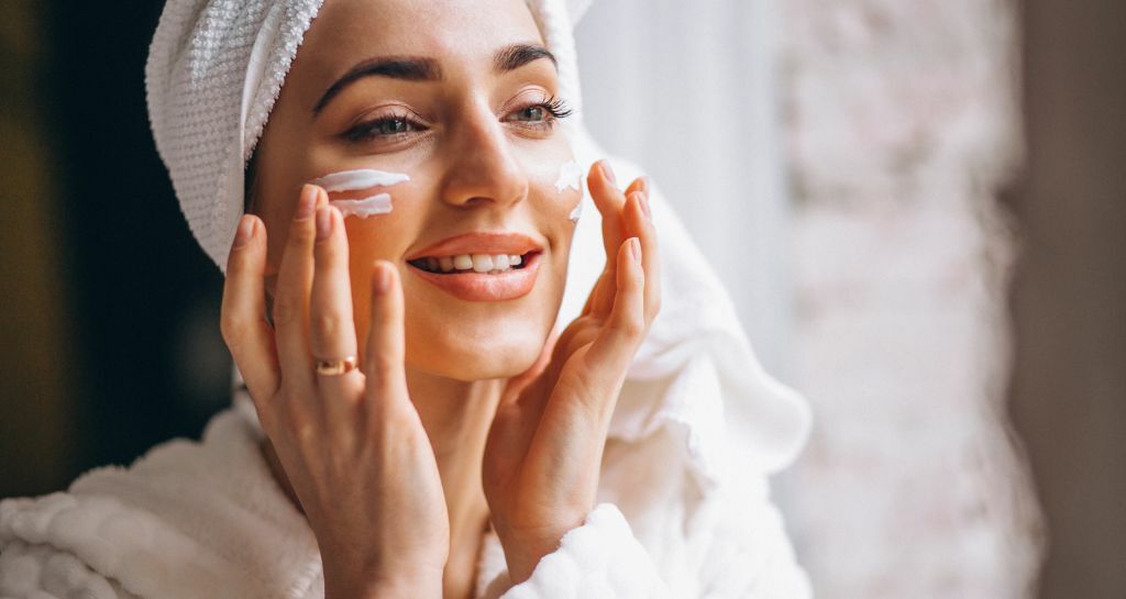 donna applica la crema in viso