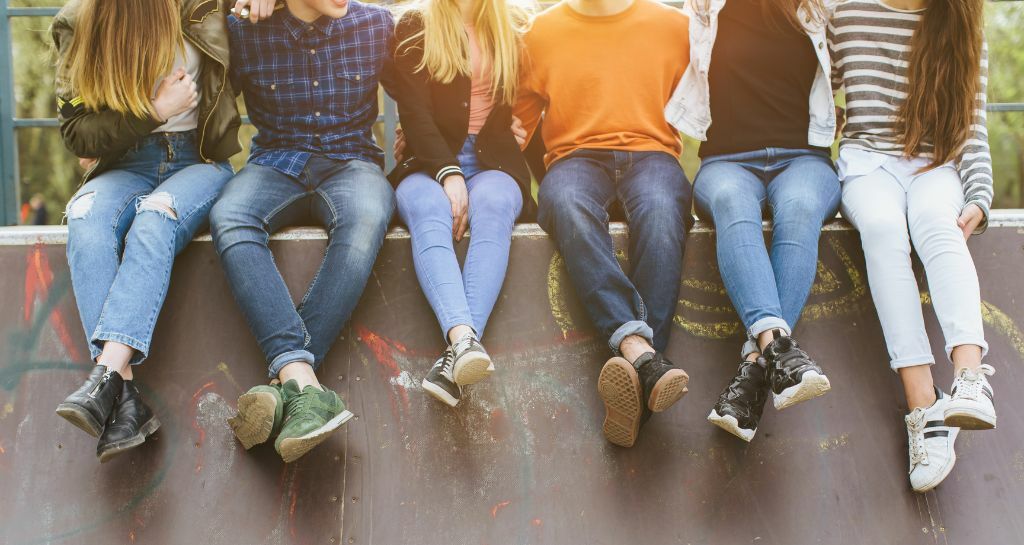 ragazzi e ragazze seduti su un muretto