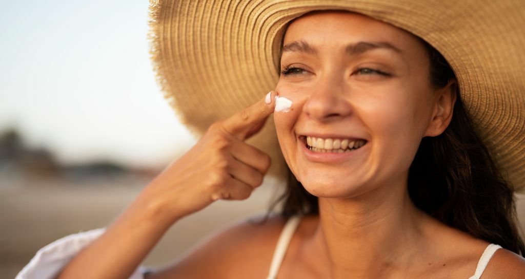 donna applica la crema in volto