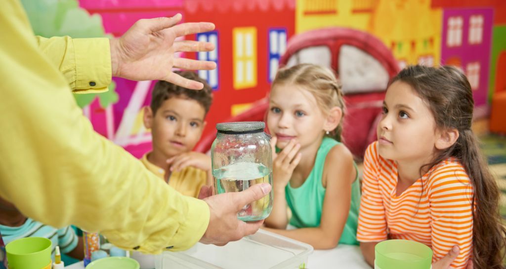 bambini osservano un esperimento con acqua 