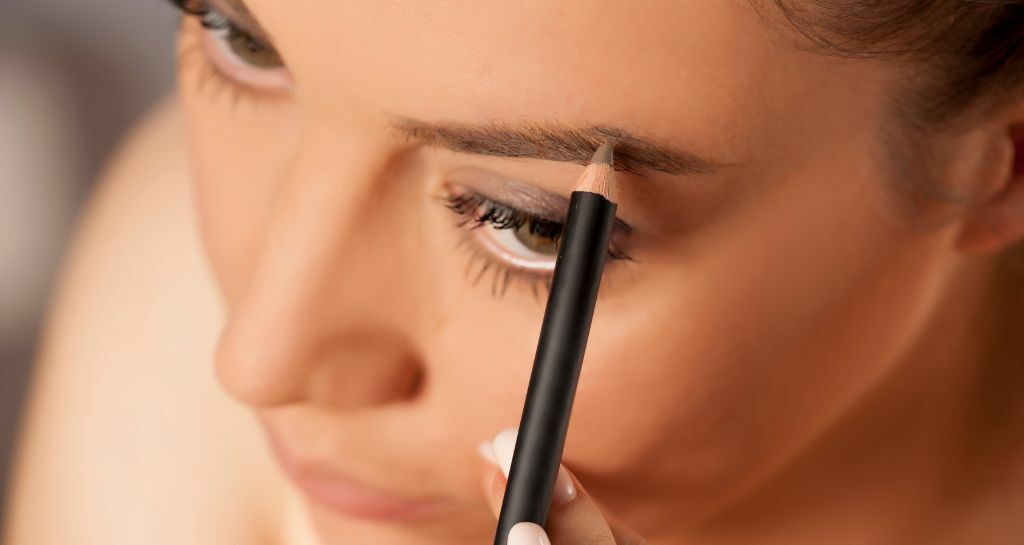 ragazza si trucca le sopracciglia