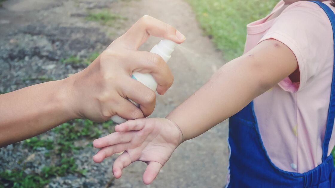 genitore spruzza repellente zanzare su figlia