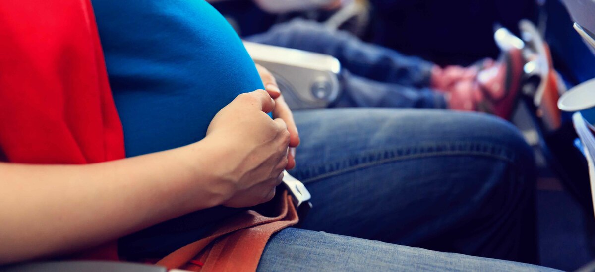 Donna in aereo in gravidanza