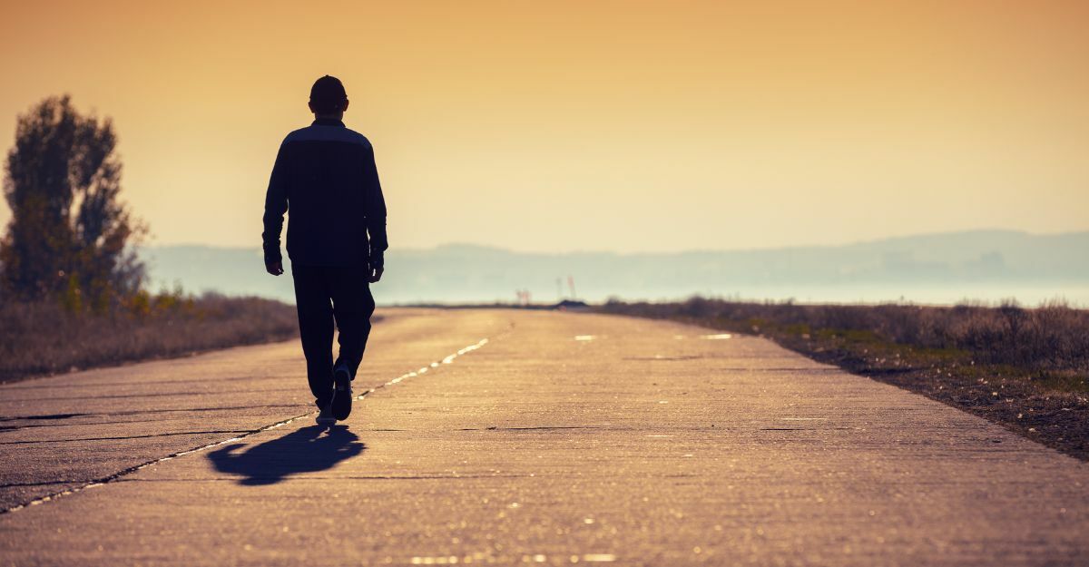 una persona cammina al tramonto