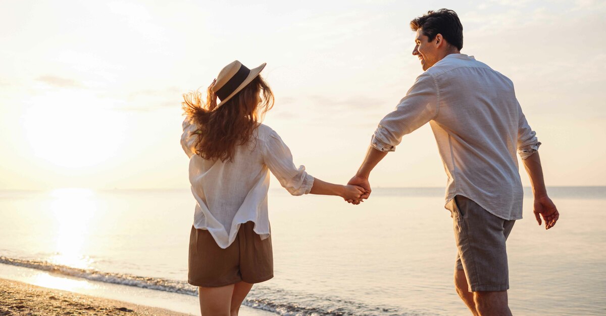 Coppia si tiene per mano sulla spiaggia