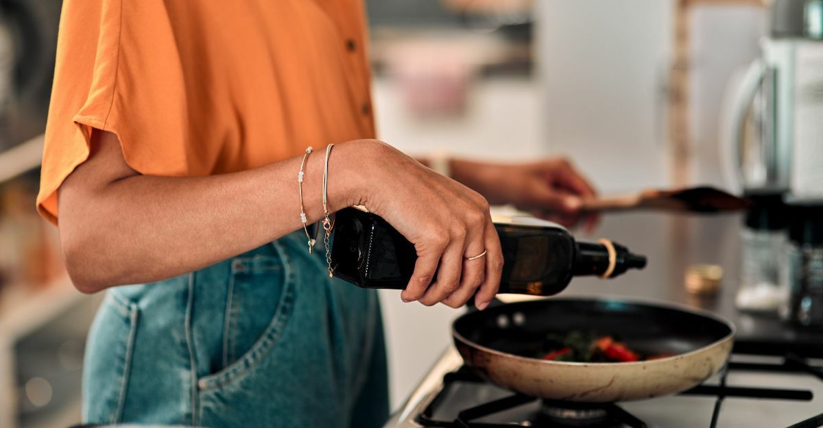 una persona aggiunge l'olio in una pentola