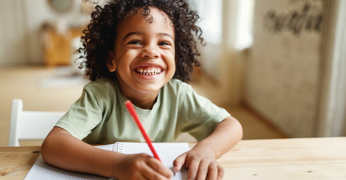 bambino sorridente che scrive