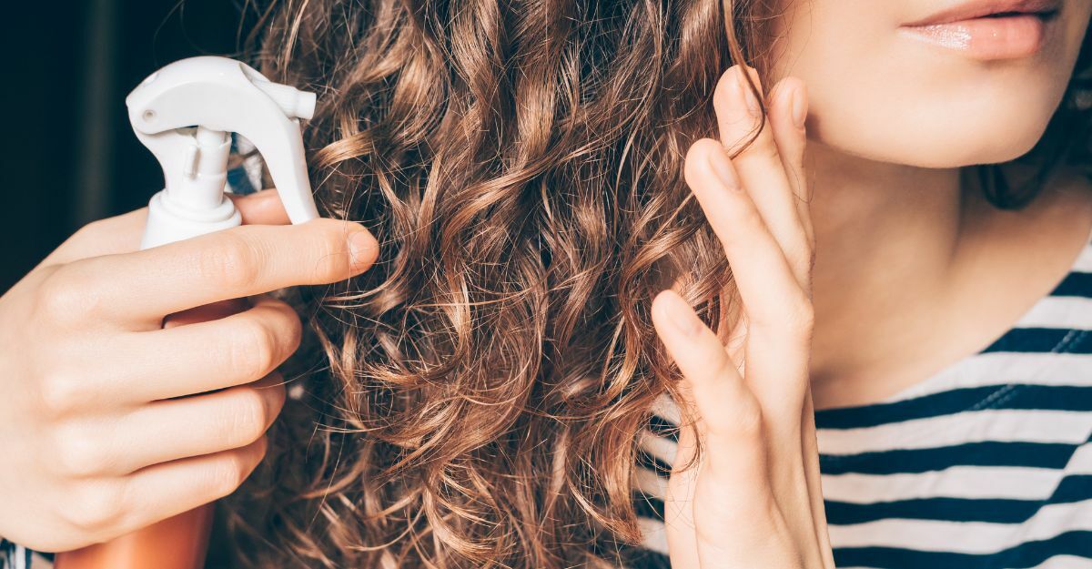 ragazza spruzza spray per capelli ricci