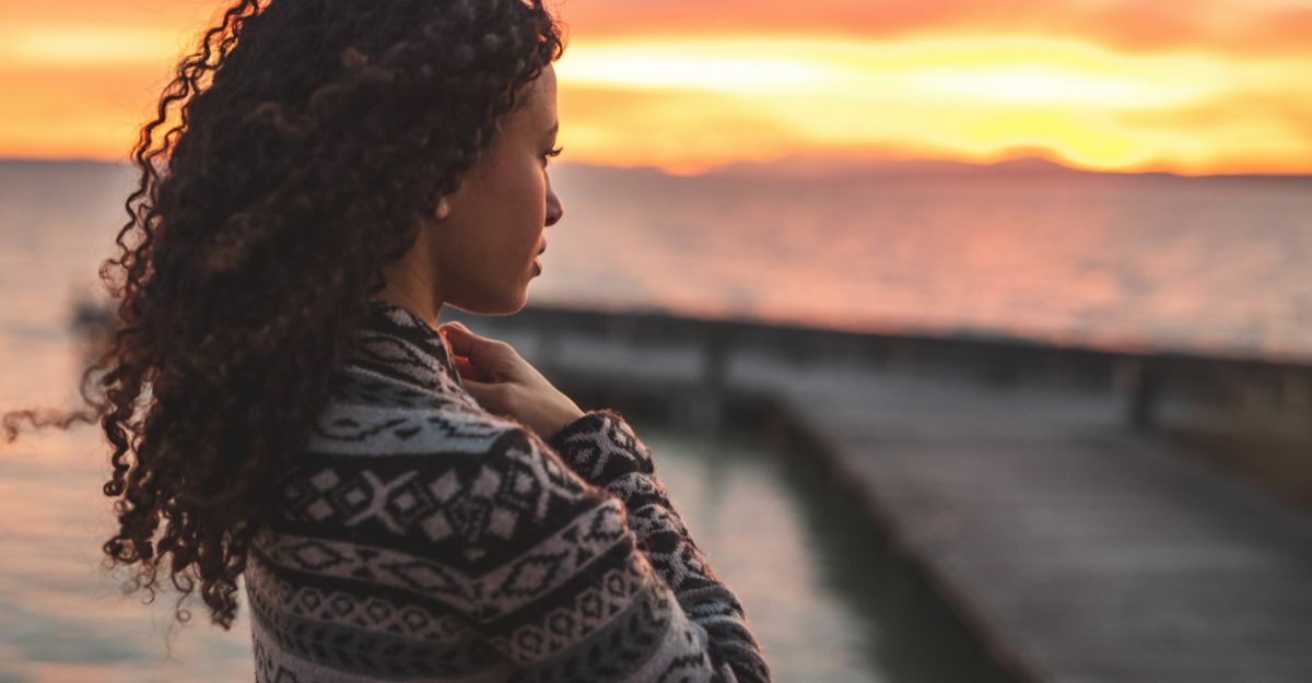 donna che guarda il tramonto sul mare
