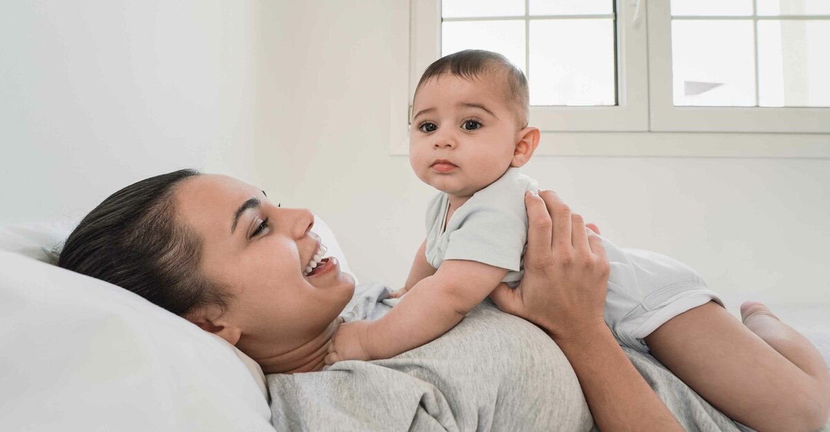 Donna a letto con in braccio il proprio figlio