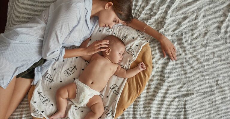 mamma che dorme nel letto con il suo bimbo