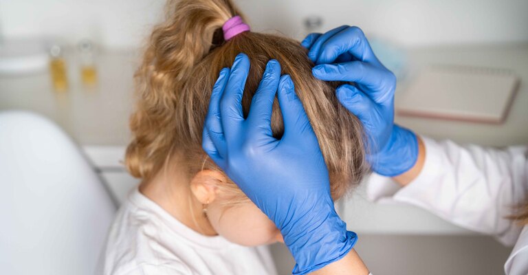 Bambina viene controllata dal medico tra i capelli