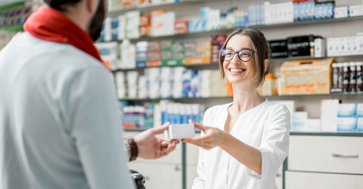 Farmacista passa una scatola di preservativi ad un ragazzo