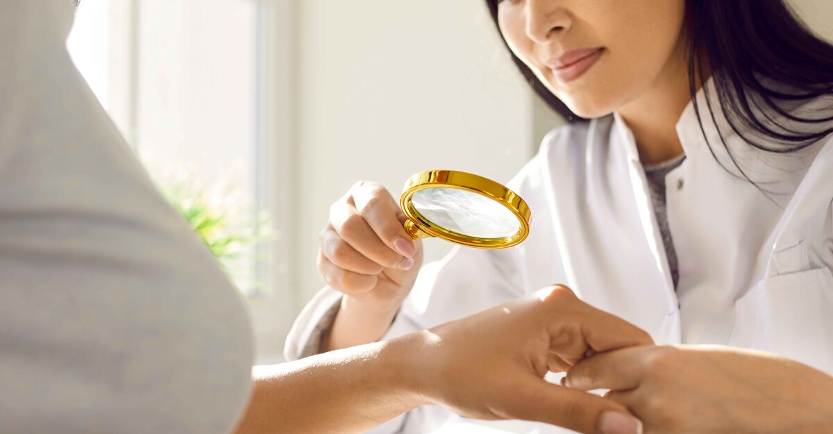 Dermatologo osserva le mani di una paziente