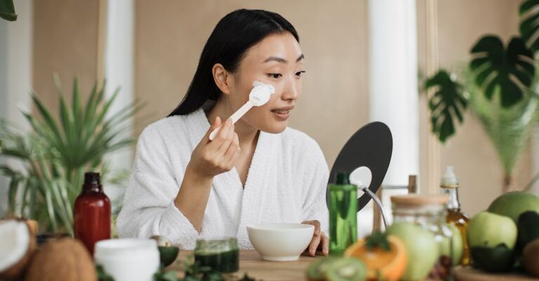 donna orientale si spalma la crema sul viso