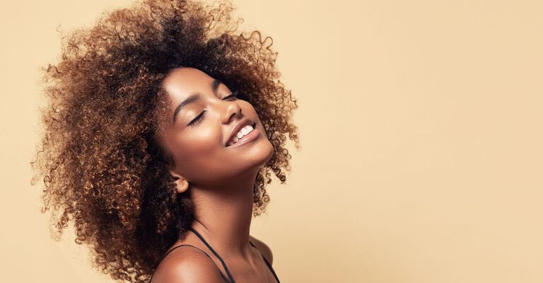 donna-sorridente-con-capelli-ricci-castani